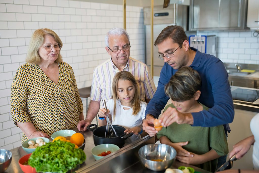 drei Generationen kochen gemeinsam in einer Küche